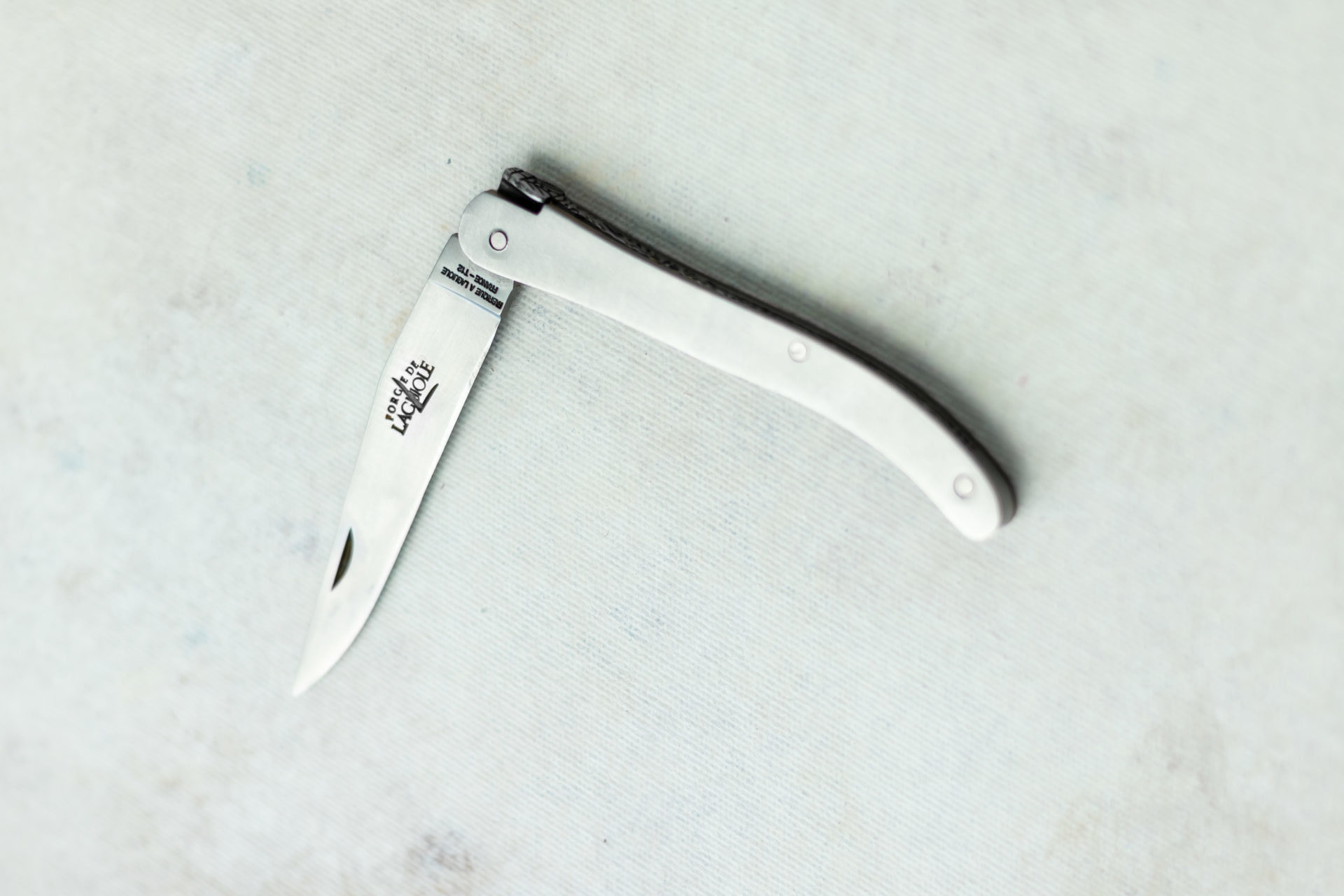 Klappmesser mit silbernem Griff und geöffneter Klinge, ideal für den täglichen Gebrauch oder Outdoor-Aktivitäten