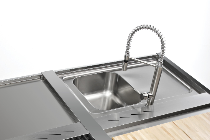 Edelstahlspüle mit flexiblem Küchenarmatur und integriertem Abtropfbereich auf Arbeitsplatte