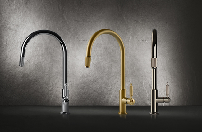 Drei elegante Küchenarmaturen in den Farben Chrom, Gold und Schwarz auf einem dunklen Untergrund vor einer Steinwand