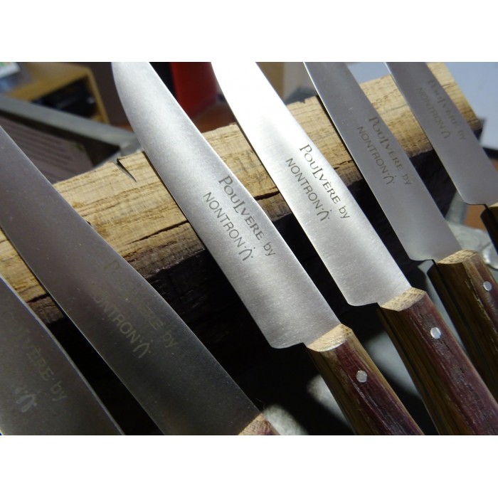 Mehrere hochwertige Nontron Steakmesser mit Holzgriffen und gravierten Klingen in einer Messerleiste
