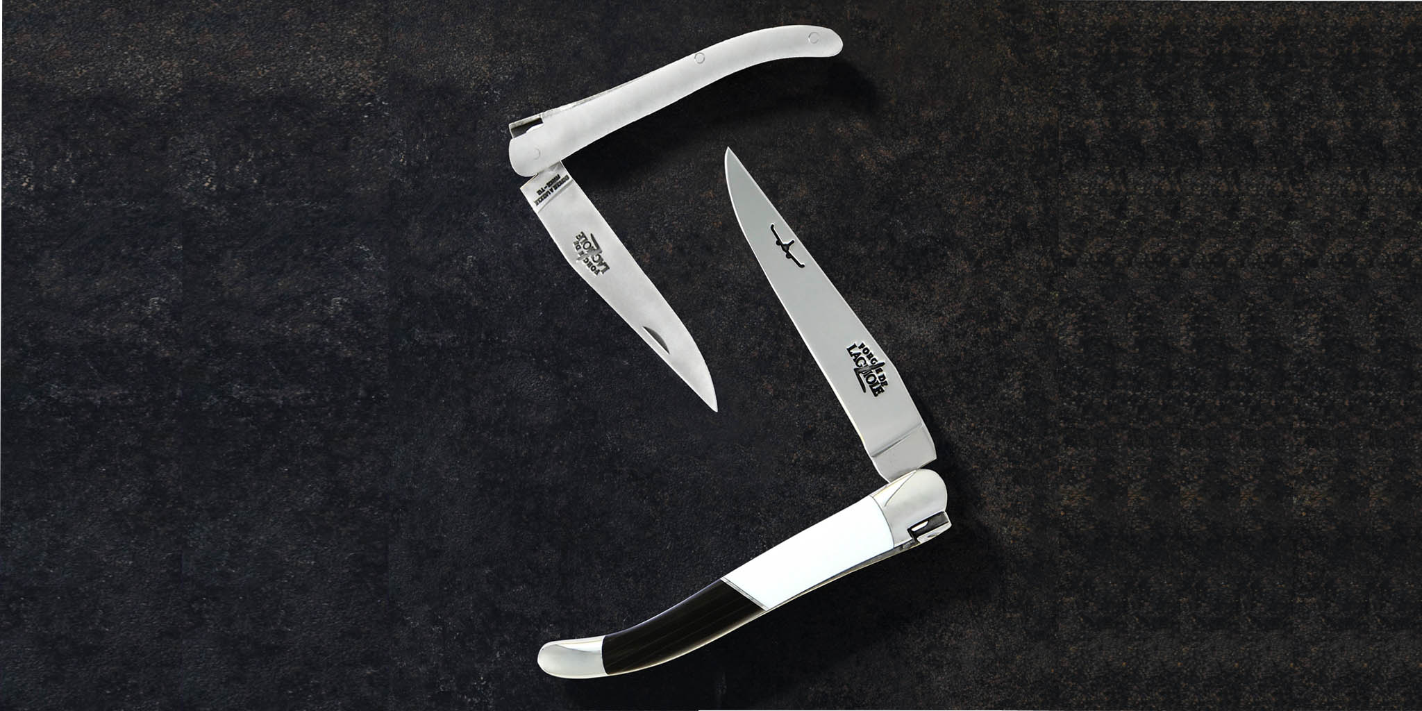 Hochwertiges Laguiole Klappmesser mit Edelstahlklinge und elegantem schwarzen Griff, geöffnet und auf dunklem Hintergrund