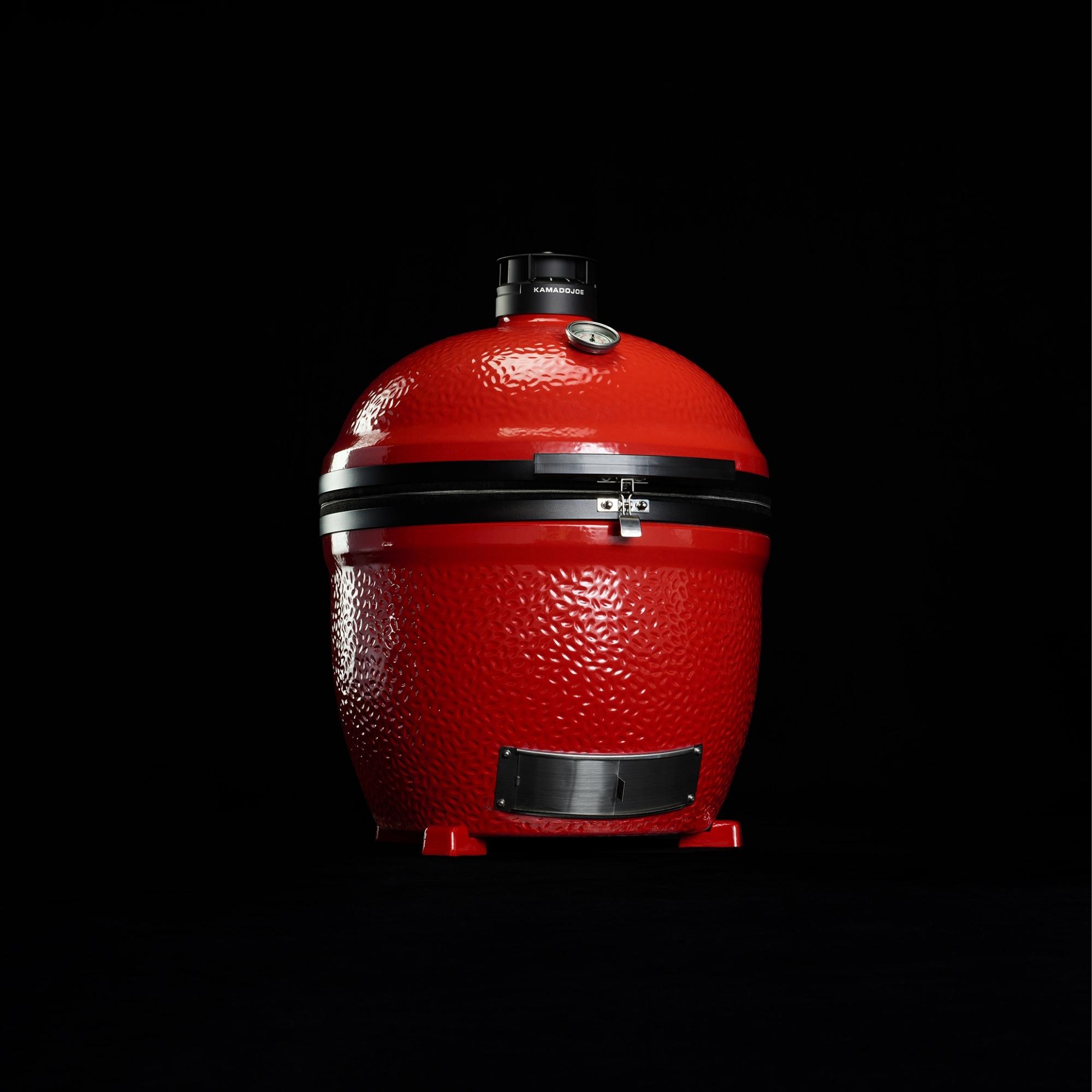 Roter Kamado Joe Classic Keramikgrill mit geschlossenem Deckel auf schwarzem Hintergrund