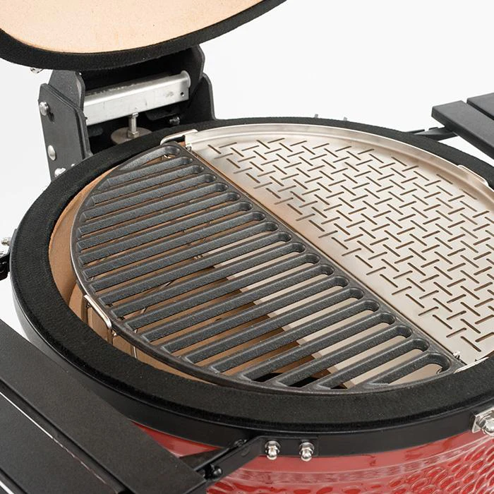 Nahaufnahme eines geöffneten Keramikgrills mit halbseitigem Gusseisenrost und halbseitiger Edelstahlplatte zur flexiblen Grillzoneneinteilung