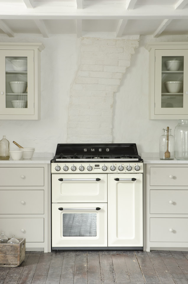 Retro Smeg Gasherd mit zwei Backöfen, cremefarben, in einer hellen Landhausküche mit weißen Schränken und Holzboden