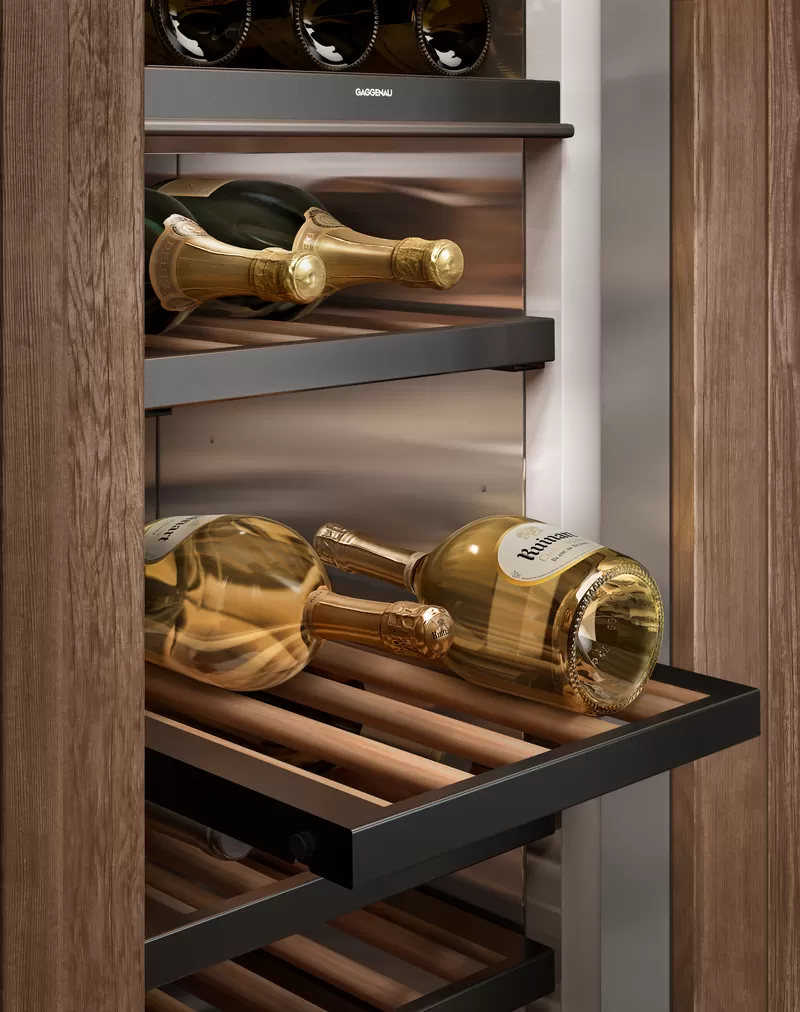 Detailansicht eines modernen Weinschranks mit ausziehbaren Holzregalen und mehreren liegenden Champagnerflaschen.