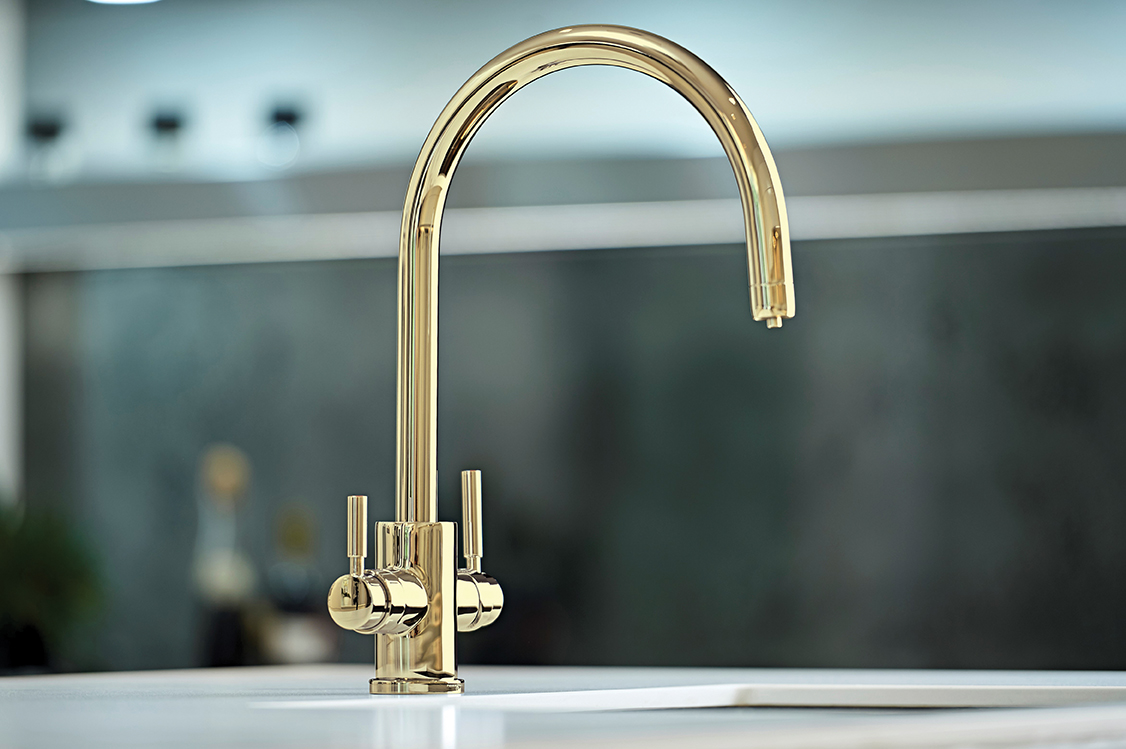 Goldene Küchenarmatur mit zwei Griffen auf weißer Spüle, modernes und elegantes Design in einem hellen Küchenumfeld