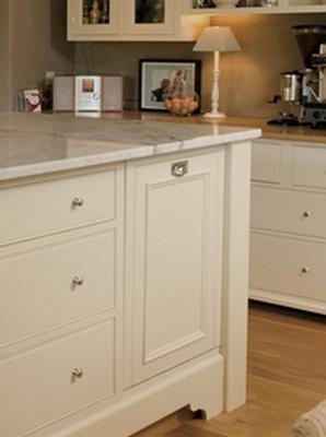 Detailansicht einer Kücheninsel in Creme mit Schubladen, Marmortheke und stilvollen Accessoires