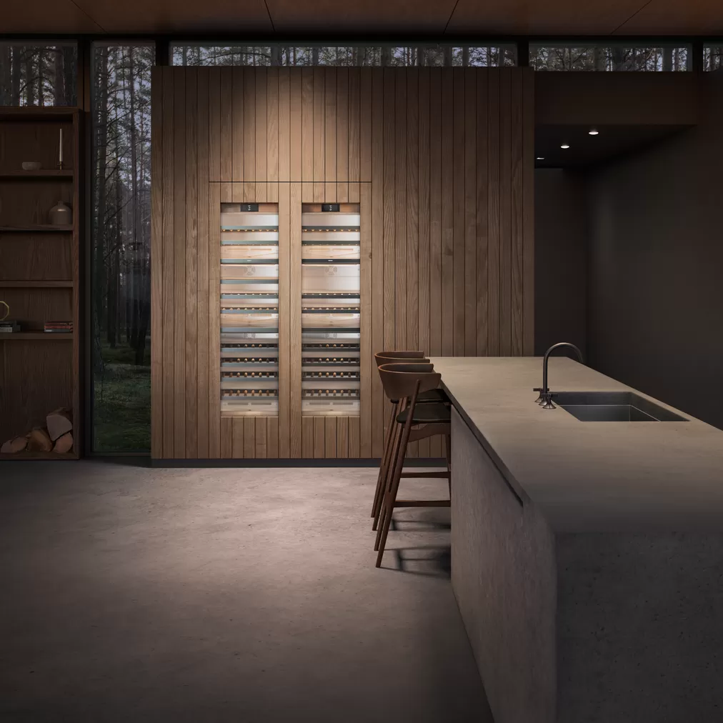 Innenansicht einer eleganten Küche mit integriertem Weinkühlschrank aus Holz, Bartresen und moderner Spüle in stilvoller Umgebung