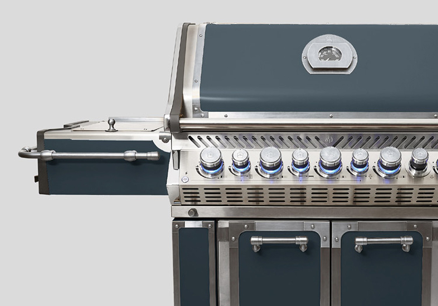 Großer Gasgrill aus Edelstahl mit mehreren Bedienelementen, seitlicher Ablage und integriertem Thermometer, ideal für Outdoor-Küche