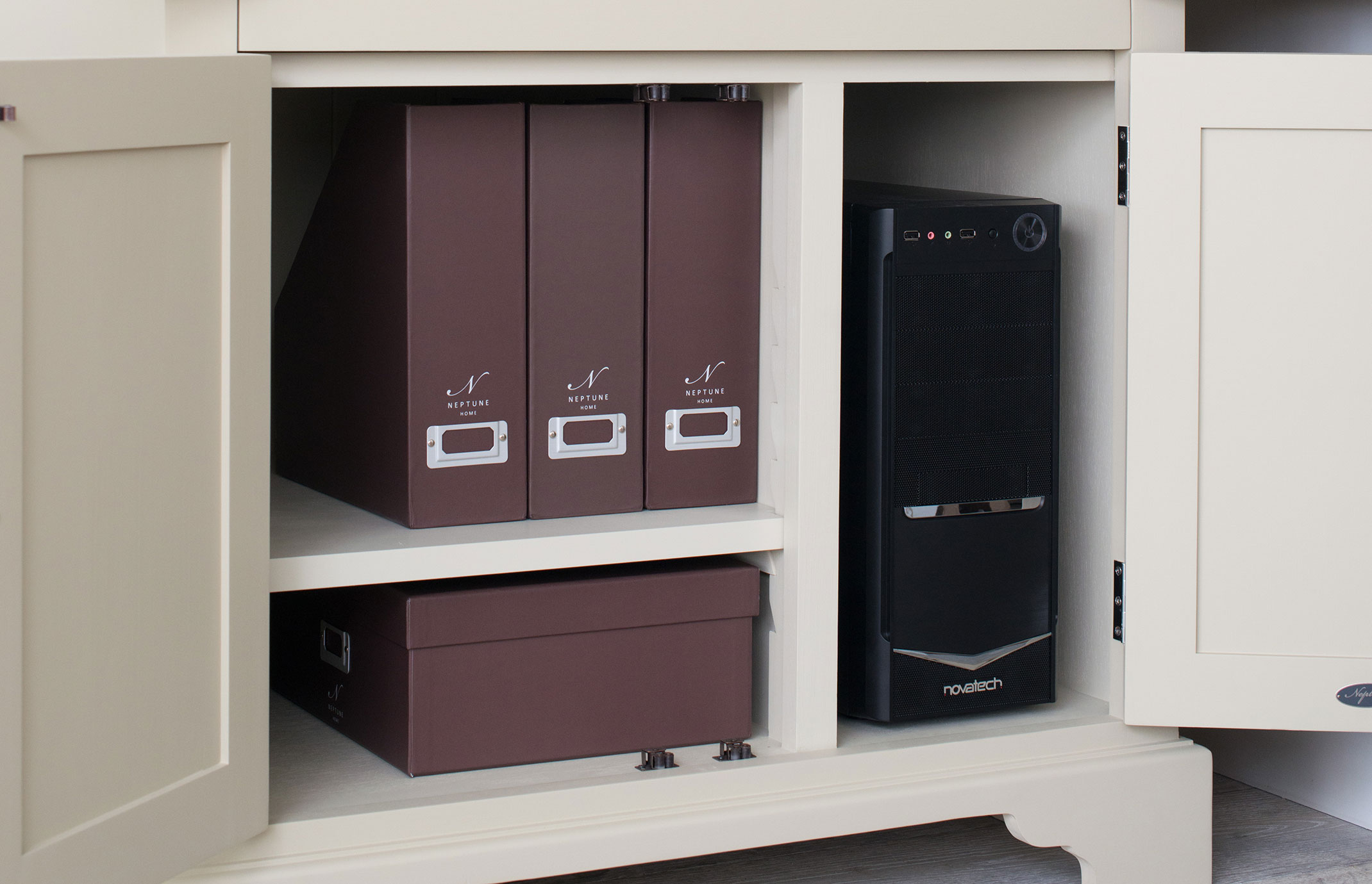 Geöffneter Schrank mit drei braunen Stehsammlern, einer Schachtel und einem schwarzen Computergehäuse