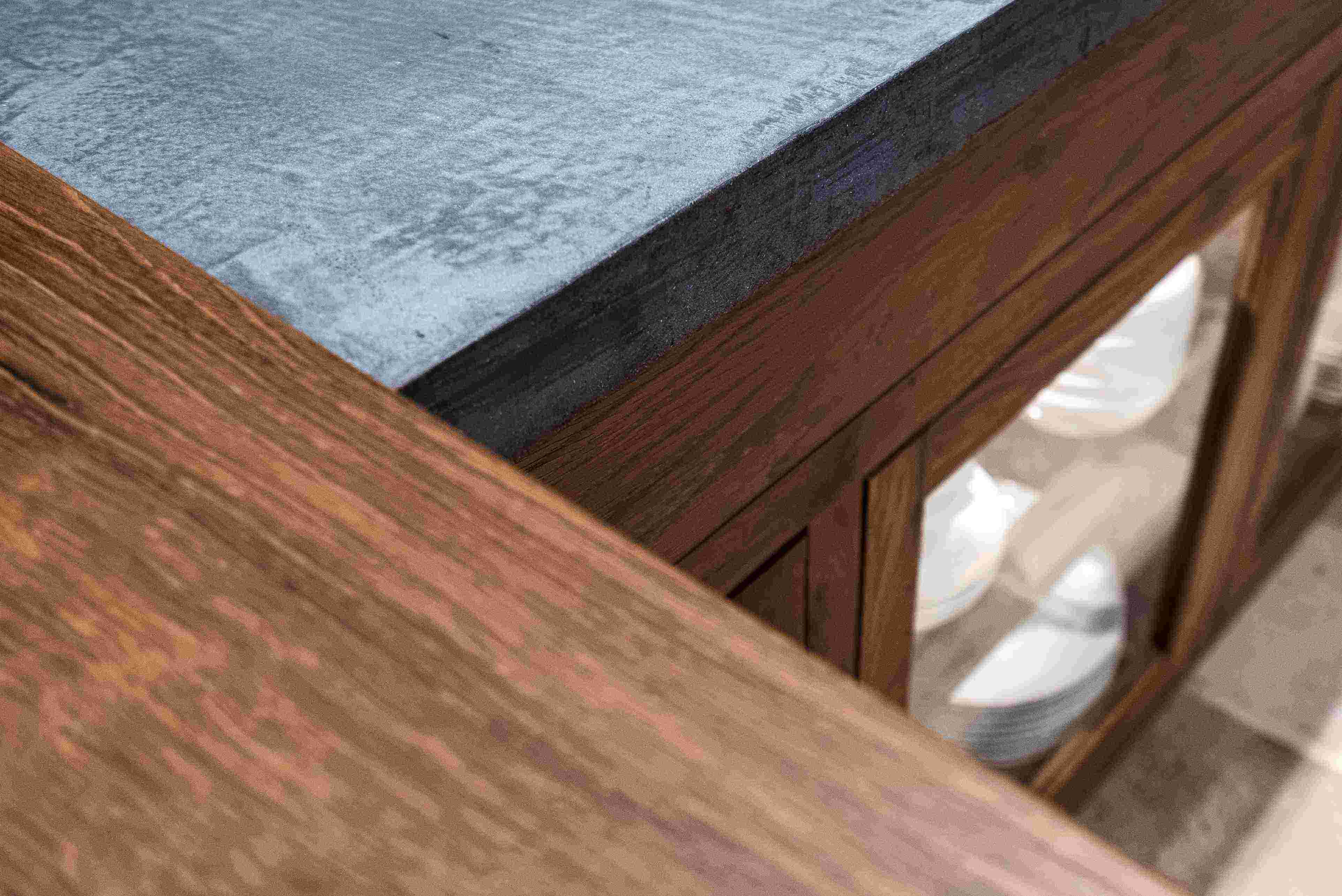 Detailaufnahme einer Küchenarbeitsplatte mit Betonoberfläche und Holzschrank