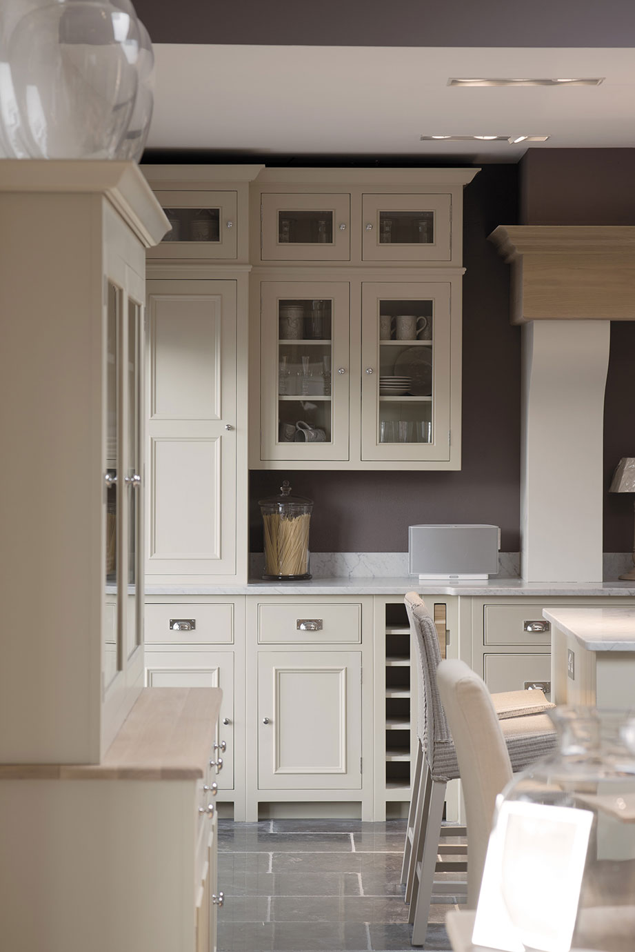 Helle Einbauküche im Landhausstil mit cremefarbenen Schränken, Glastüren, Marmorarbeitsplatte und eleganten Details