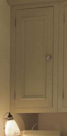 Geschlossener, beiger Oberschrank mit schlichter Front und rundem Metallgriff in einer Küche