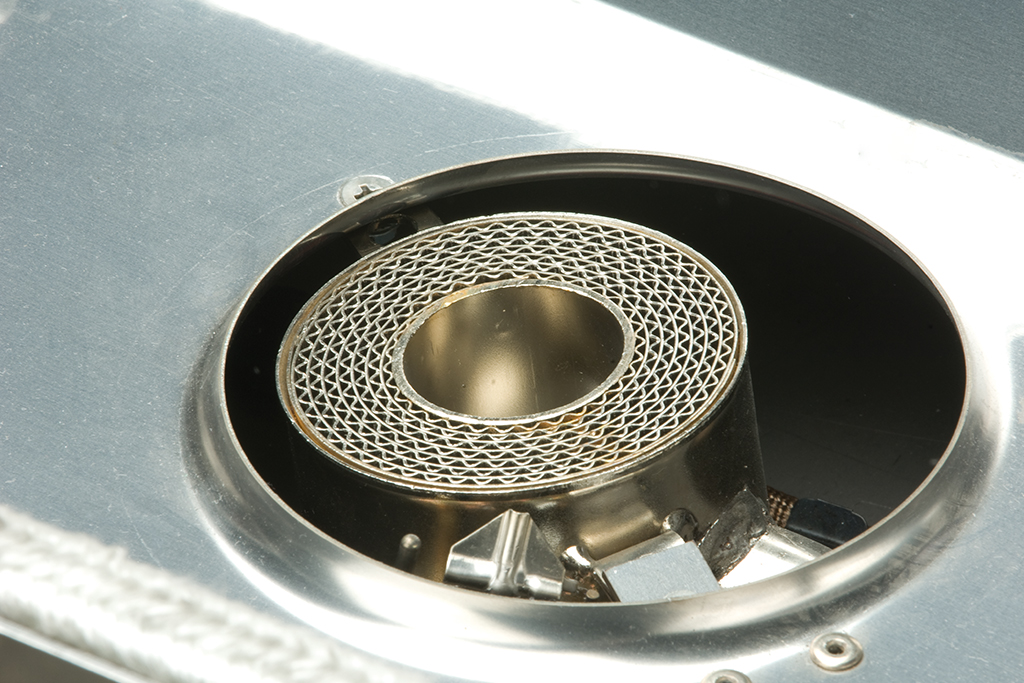 Detailansicht eines Metallkatalysators in einem technischen Gerät, Fokus auf das wabenförmige Innenteil