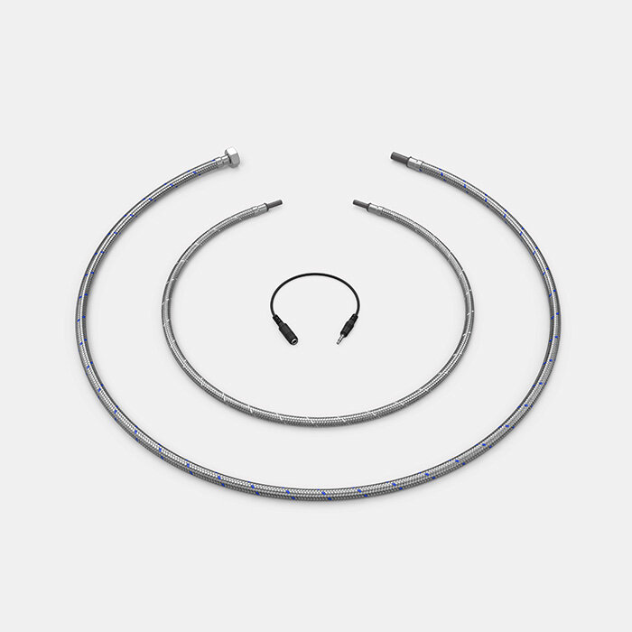 Set aus zwei flexiblen Metallschläuchen und einem Adapter für Wasserhähne auf weißem Hintergrund