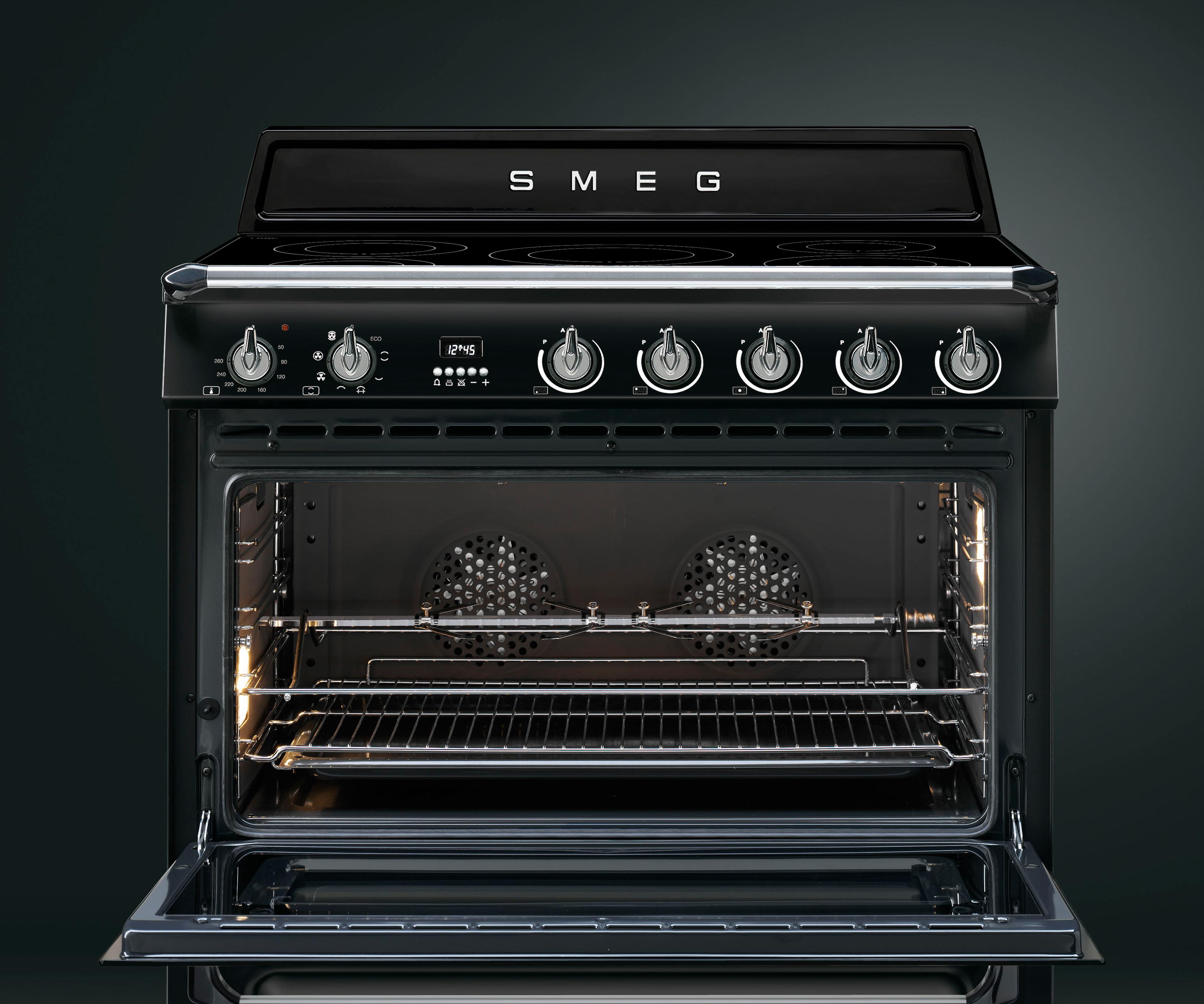 Schwarzer Smeg Standherd mit offenem Backofen, erkennbaren Backblechen und Drehknöpfen zur Temperatursteuerung