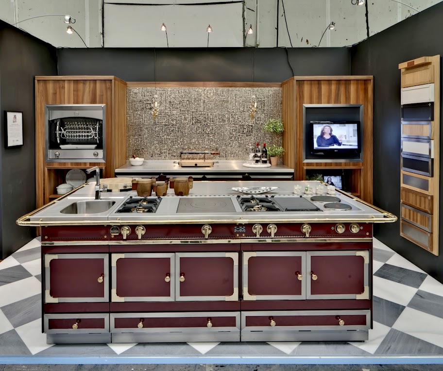 Küche mit großer Kochinsel, edlen Holzelementen, Backofen, Spüle und integriertem Fernseher in modernem Design