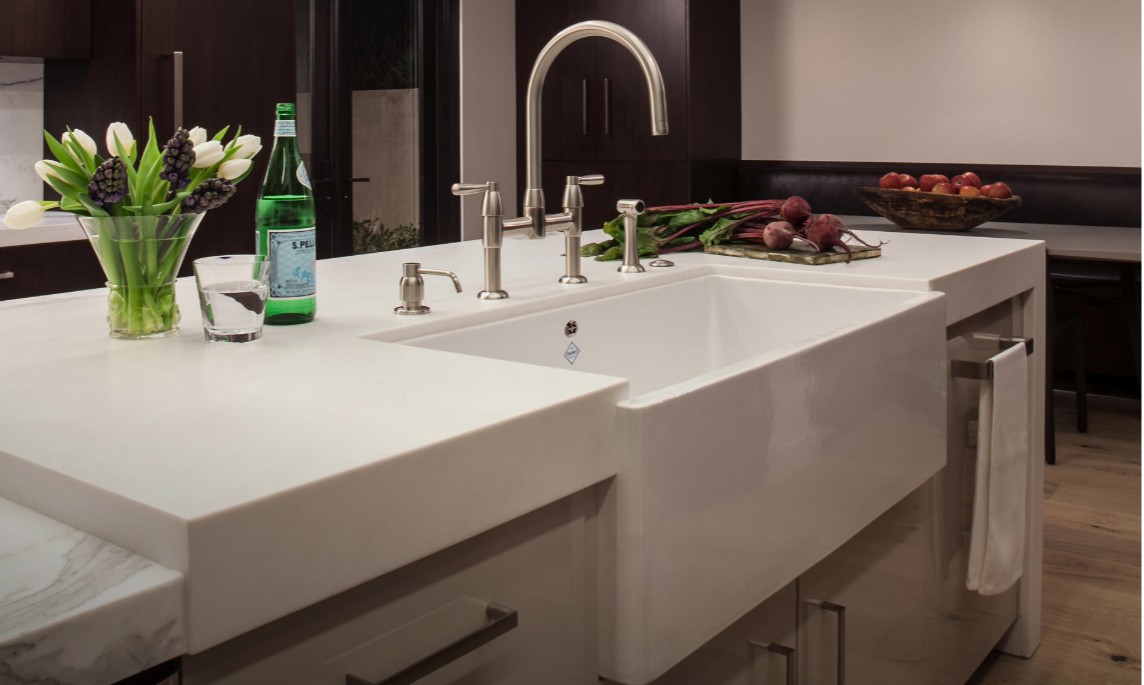 Moderne Kücheninsel mit weißer Keramik-Apron-Front-Spüle: tiefes Einzelbecken, hoher Auslauf, Seifenspender und Handtuchhalter – ideal zum Vorbereiten von Lebensmitteln