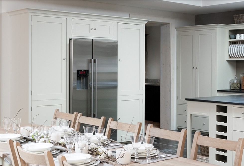 Helle, moderne Küche mit integriertem Side-by-Side-Kühlschrank aus Edelstahl und festlich gedecktem Esstisch