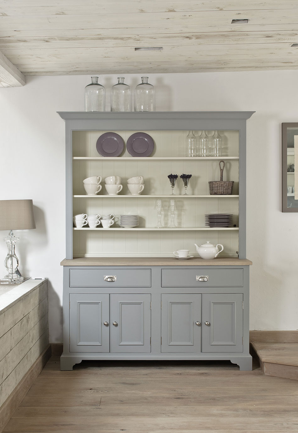 Küchenbuffet im Landhausstil in Grau mit Geschirr, Gläsern und Dekoration in einem modernen Wohnraum