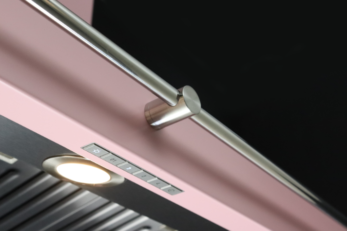 Moderne Dunstabzugshaube in Rosa mit Edelstahlgriff, Bedientasten und integrierter Beleuchtung