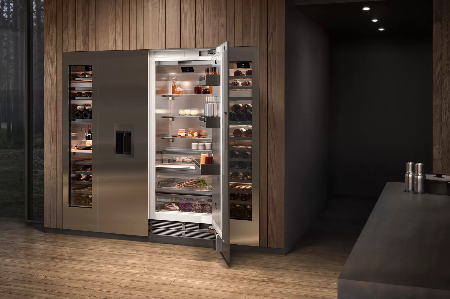 Hochwertiger, großer Einbau-Kühlschrank aus Edelstahl mit offener Tür, daneben zwei Weinkühlschränke, in eleganter Küchenumgebung