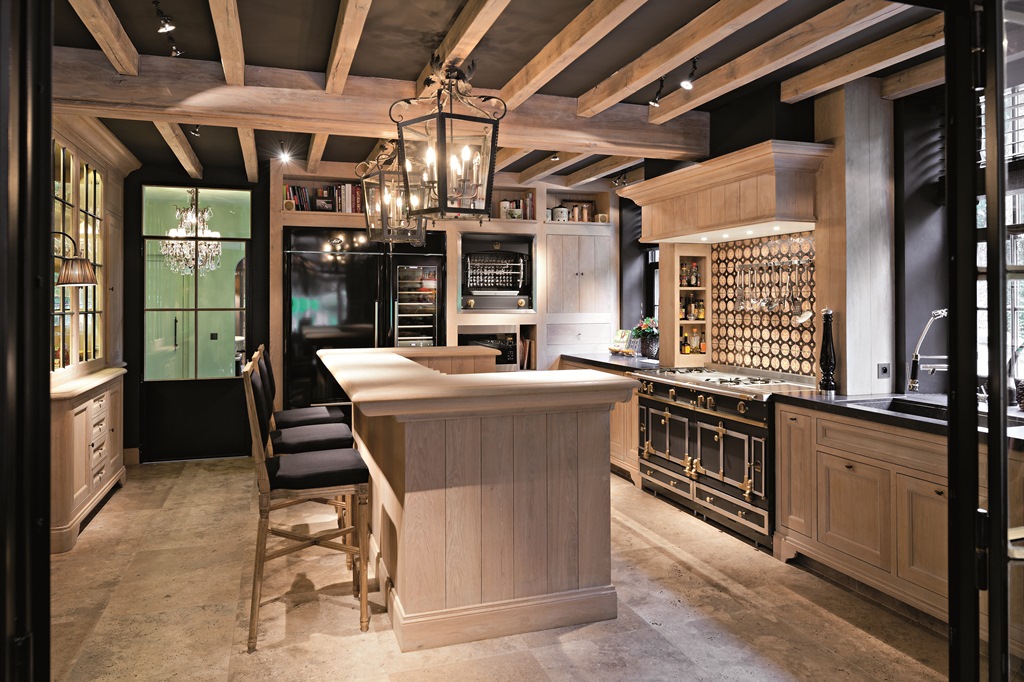 Elegante, moderne Landhausküche mit Holzfronten, großzügiger Kücheninsel, schwarzem Herd mit goldenen Akzenten und offenen Regalen