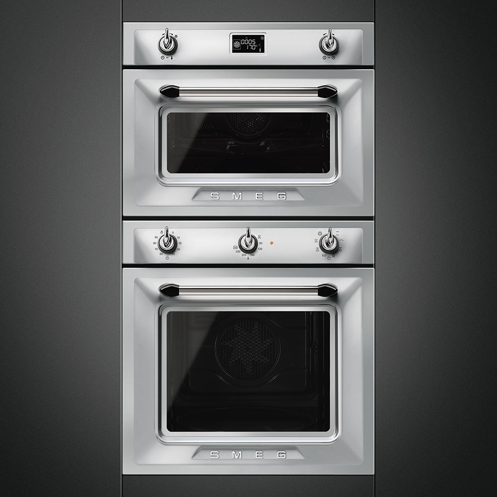 Smeg Doppelbackofen in silberner Retro-Optik, eingebaut in eine dunkle Küchenwand, beide Öfen mit Sichtfenster und Drehknöpfen