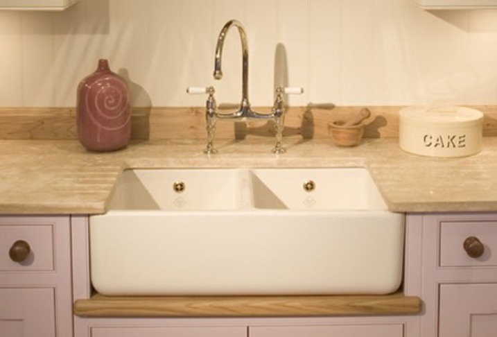 Keramik-Doppelspülbecken mit goldenen Armaturen, Marmorarbeitsplatte und Küchenaccessoires in Landhausstil
