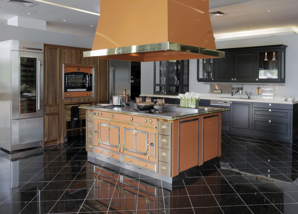 Moderne Premiumküche mit zentraler Kochinsel in Kupfer, Dunstabzugshaube, Edelstahlschrank, Backofen und eleganten schwarzen Schränken