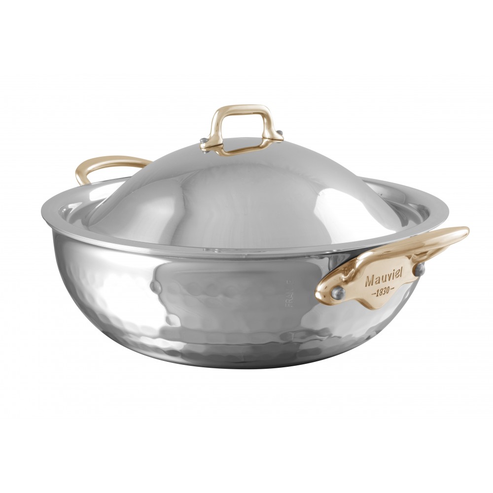 Edelstahl-Wok mit glänzender Oberfläche, Messinggriffen und passendem Deckel der Marke Mauviel, ideal für vielseitiges Kochen