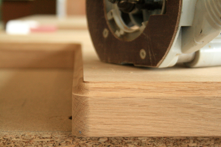 Detailaufnahme einer Fräse, die eine Holzkante abrundet, zur professionellen Bearbeitung von Holzoberflächen