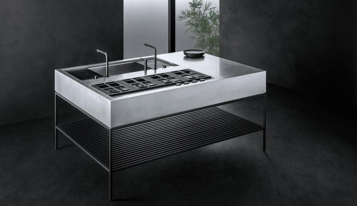 Design-Kücheninsel aus gebürstetem Edelstahl mit Kochfeld, Spüle und Ablagefläche, freistehend im Raum