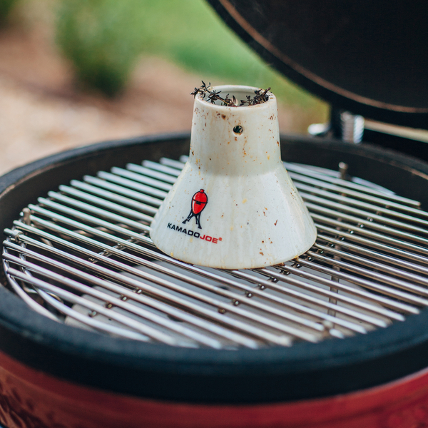Keramischer Geflügelhalter von Kamado Joe auf dem Grillrost eines geöffneten Grills, ideal zum Grillen von Hähnchen