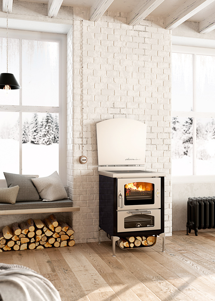 Moderner Holzofen mit brennendem Feuer, daneben eine Sitzbank mit Kissen, Holzscheite darunter und verschneite Landschaft vor dem Fenster