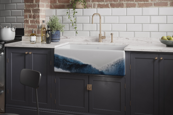 Stilvolle Küchenspüle mit blau-weißem Wellendesign, goldener Wasserhahn, dunkle Schränke und Marmor-Arbeitsplatte in moderner Küche