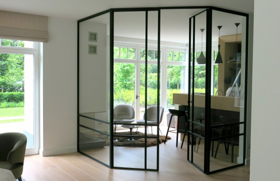 Schwarze Stahl-Glas-Raumtrennung in einem hellen, modernen Wohnbereich mit Blick auf den Essbereich und die große Fensterfront