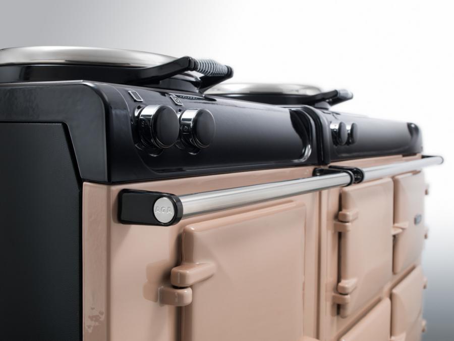 Nahaufnahme eines cremefarbenen AGA Herdes mit silbernen Drehknöpfen und Metallgriff, ideal für stilvolle Küchen